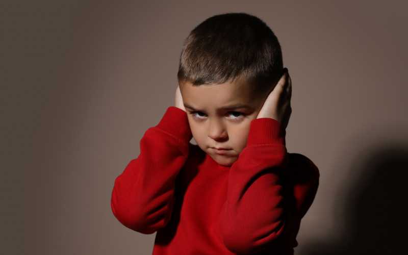 niño que proteje sus oídos